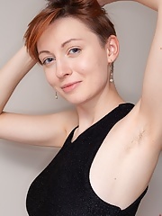 Redhead Ginta wearing a sexy black dress strips to masturbate