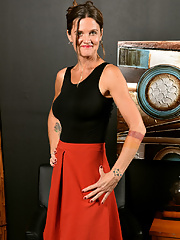 Tattooed mature brunette CJ with hot ass and big tits posing in solo scene